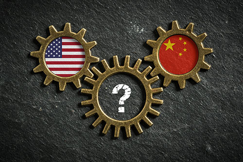 Three gear wheels with an American flag in one, a Chinese flag in another and a question mark in the third