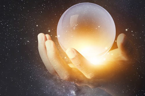 Hand holding glowing crystal globe