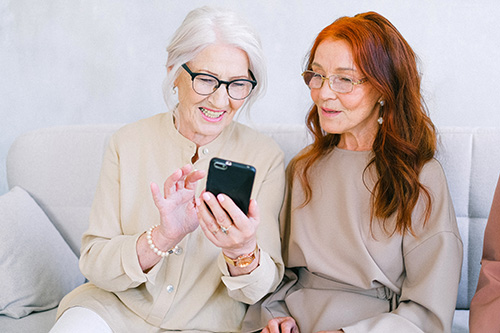 One woman with a cellphone instructing another.