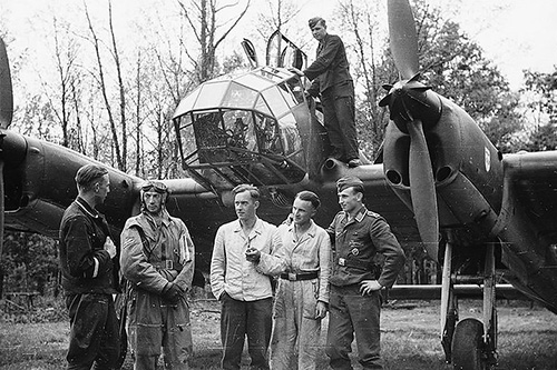 WWII soldiers standing infant of a plane