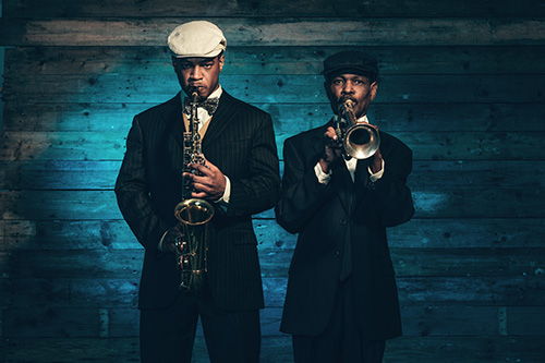 Two jazz musicians standing up and playing their instruments