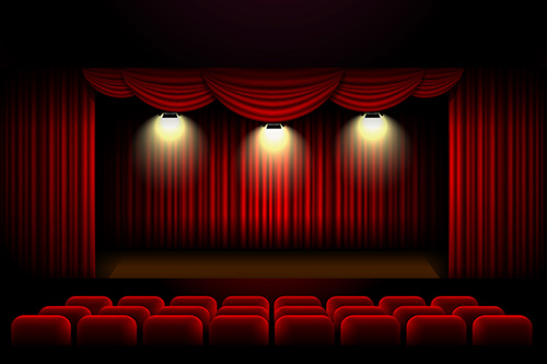 Old time theater with red velvet curtains and seats