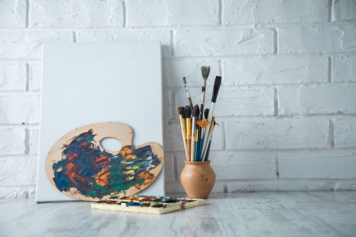 Artist's palette and vase with paint brushes