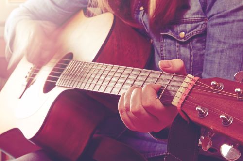 Music: Female playing guitar Torso of woman playing guitar