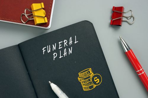 Notebook marked "Funeral Planning" and pens