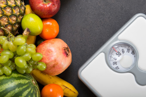 Health: Healthy Food and Weight Scale Fruit on left side, scale in right corner