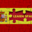 Red and yellow puzzle with the words Learn Spanish on it.