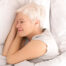 Healthy senior woman napping in bed, top view, panorama