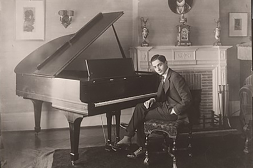 Photo of Irving Berlin sitting at a piano