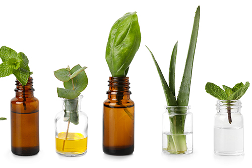Bottles with different essential oils on white background