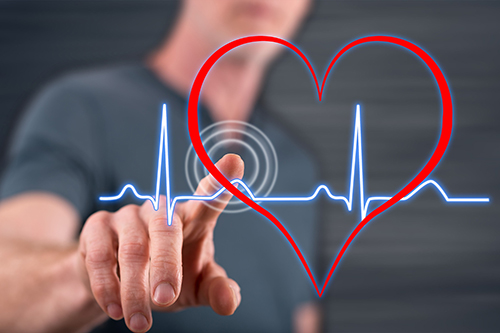 Man touching a heart beats graph on a touch screen with his finger