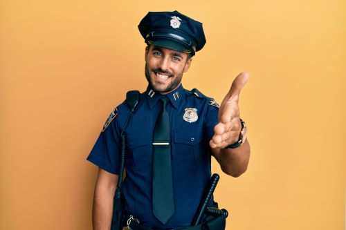 Photo of smiling police officer holding his hand out