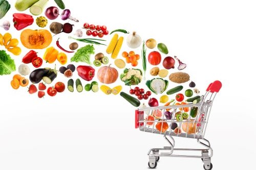 Photo of grocery shopping cart with healthy foods flowing into it