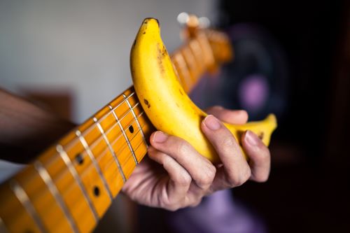 Humor in music Person using a banana as a slide guitar pick