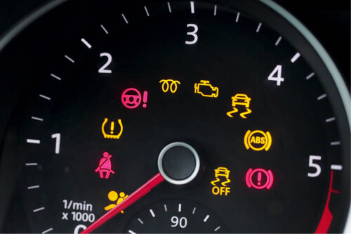 Up close of car dashboard with warning lights