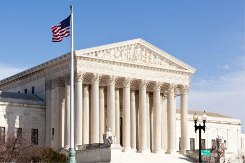 Photo of Supreme Court with flag in front