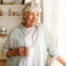 Woman holding coffee cup looking out window