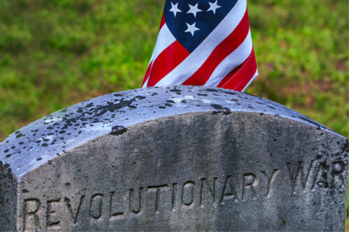 Headstone with American flag behind it