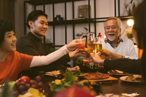 Photo of family around table toasting in celebration