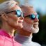 Two people looking forward into the sun wearing sunglasses