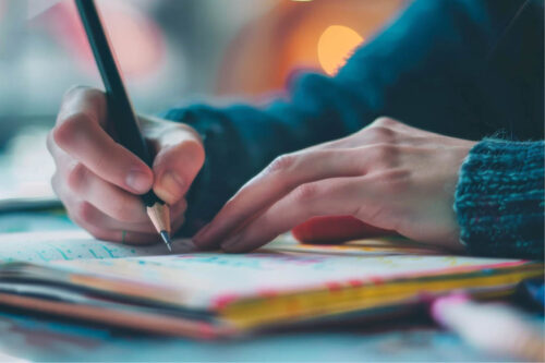 person writing in notebook