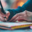 person writing in notebook