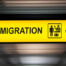 Glowing sign that has an arrow pointing right and the word "Immigration"
