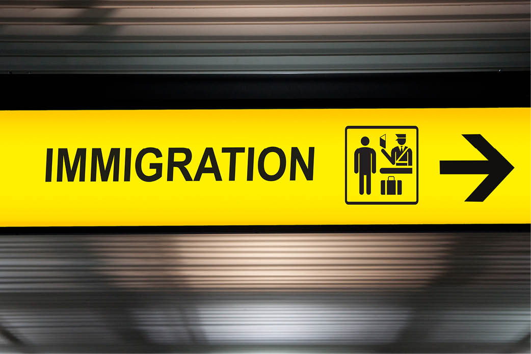 US Immigration Policy Glowing sign that has an arrow pointing right and the word "Immigration"