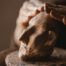 hands molding a clay sculpture of a face