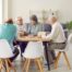 Older adults sitting at a table discussing a book